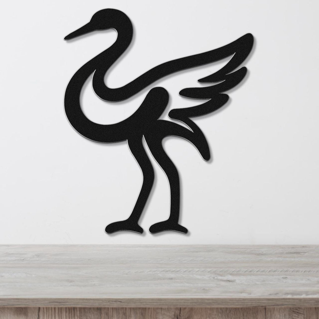 Black metal crane wall art with a minimalist silhouette design, mounted on a white wall above a light wood surface.