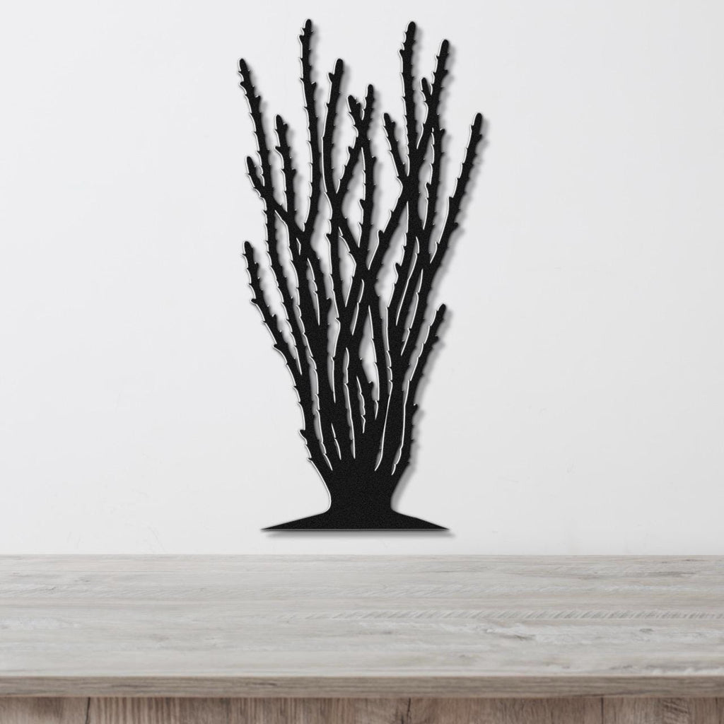 Black metal wall art cutout of an ocotillo plant with branching stems, mounted on a white wall above a light wood counter.