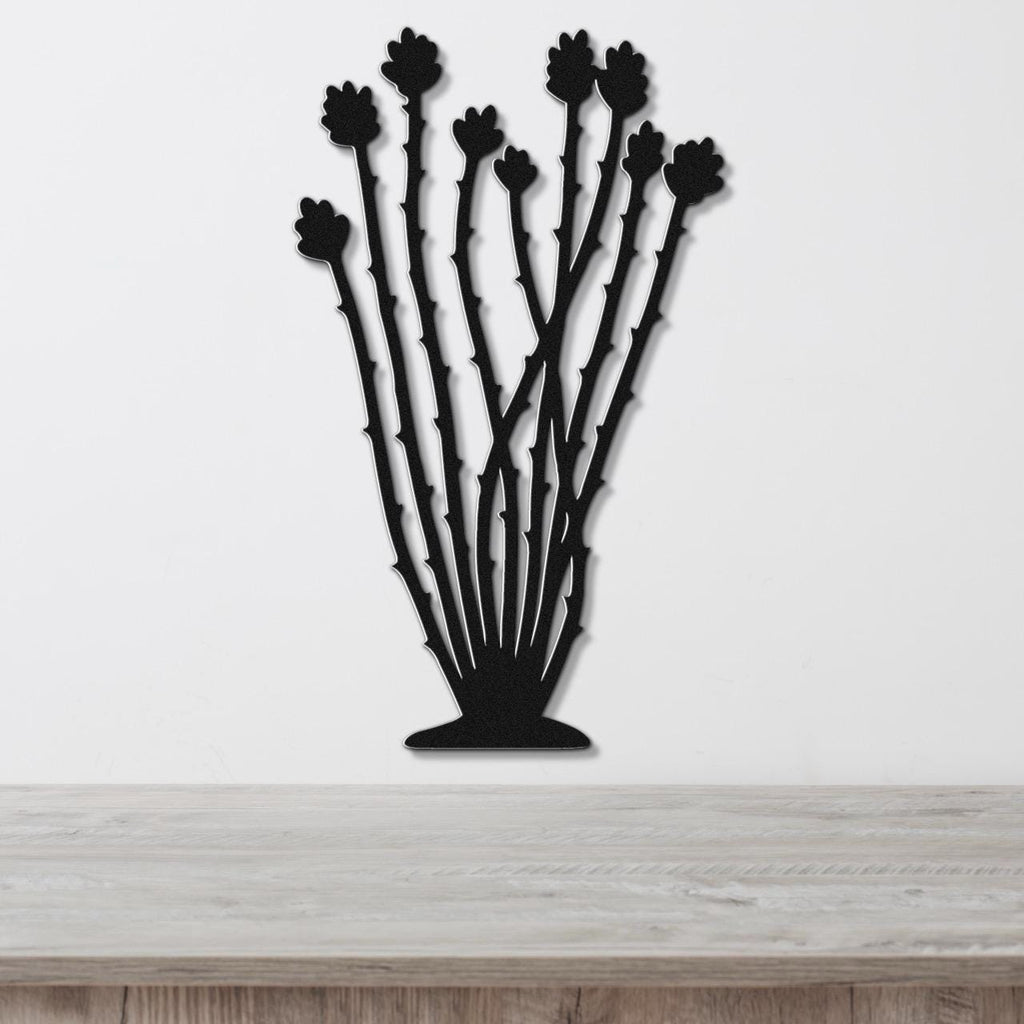 Black metal ocotillo wall art with spiny stems and flower cutouts, mounted on a white wall above a light wood counter.