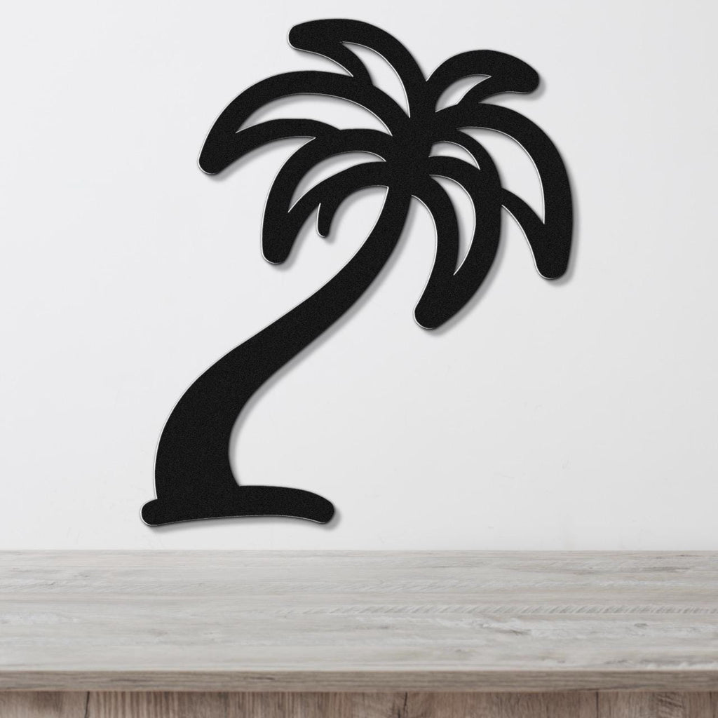 Black metal palm tree wall art with cutout fronds, mounted on a white wall above a light wood surface.