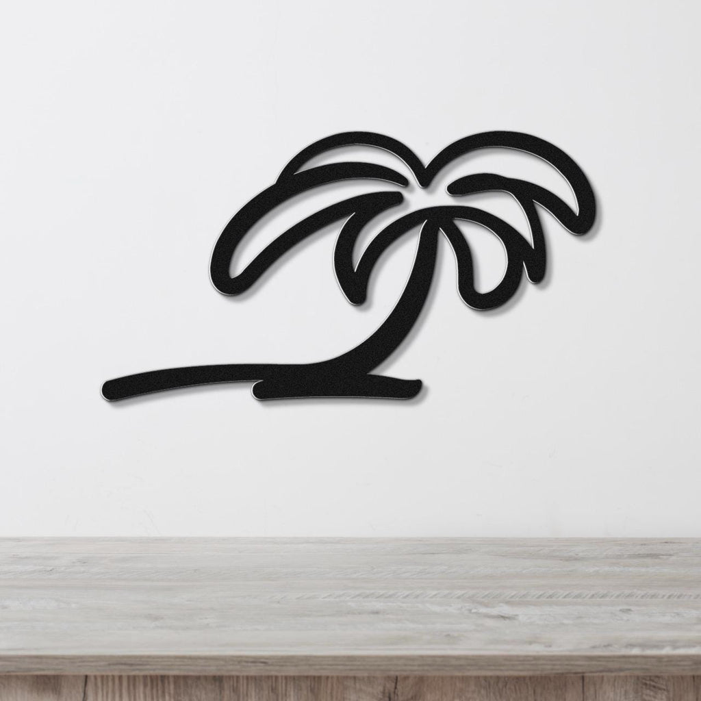 Black metal palm tree wall art with a silhouette cutout design, mounted on a white wall above a light wood surface.