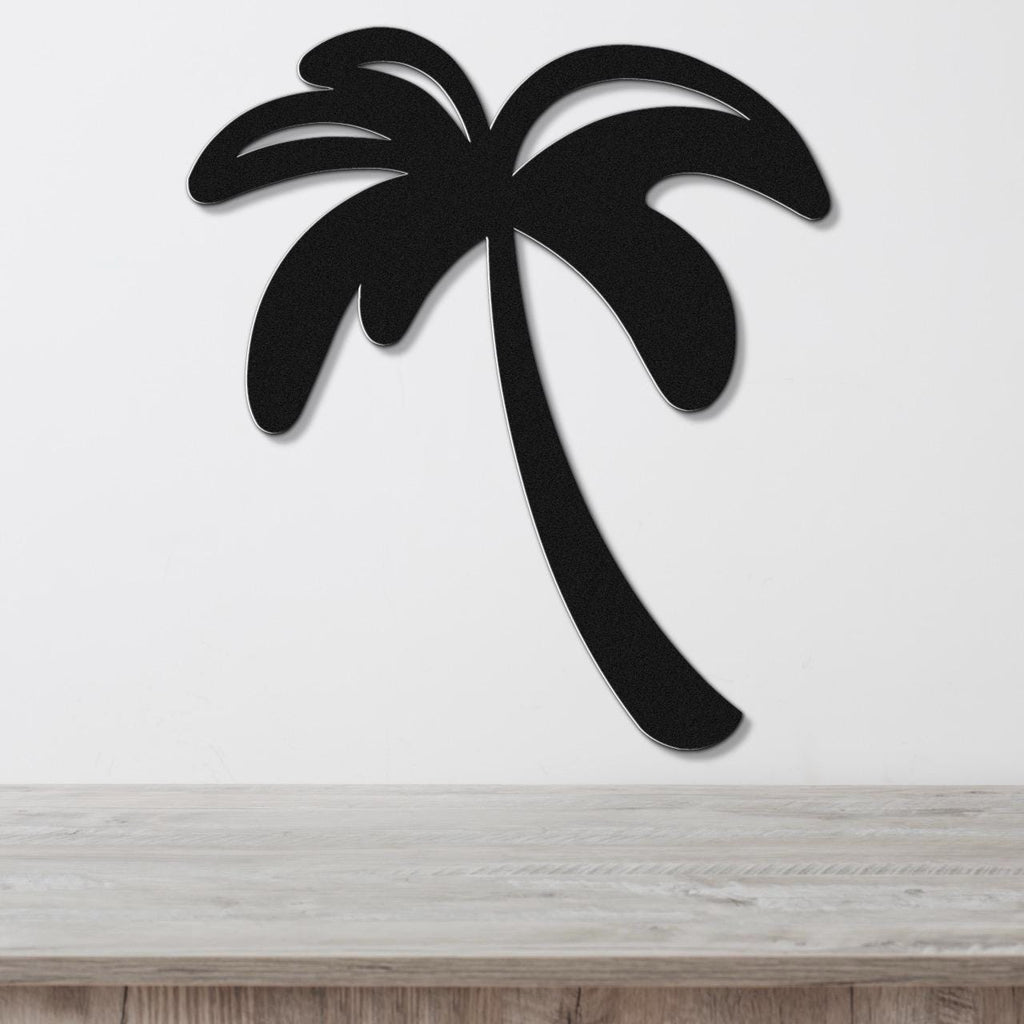 Black metal palm tree wall art with a silhouette cutout design, mounted on a white wall above a light wood surface.