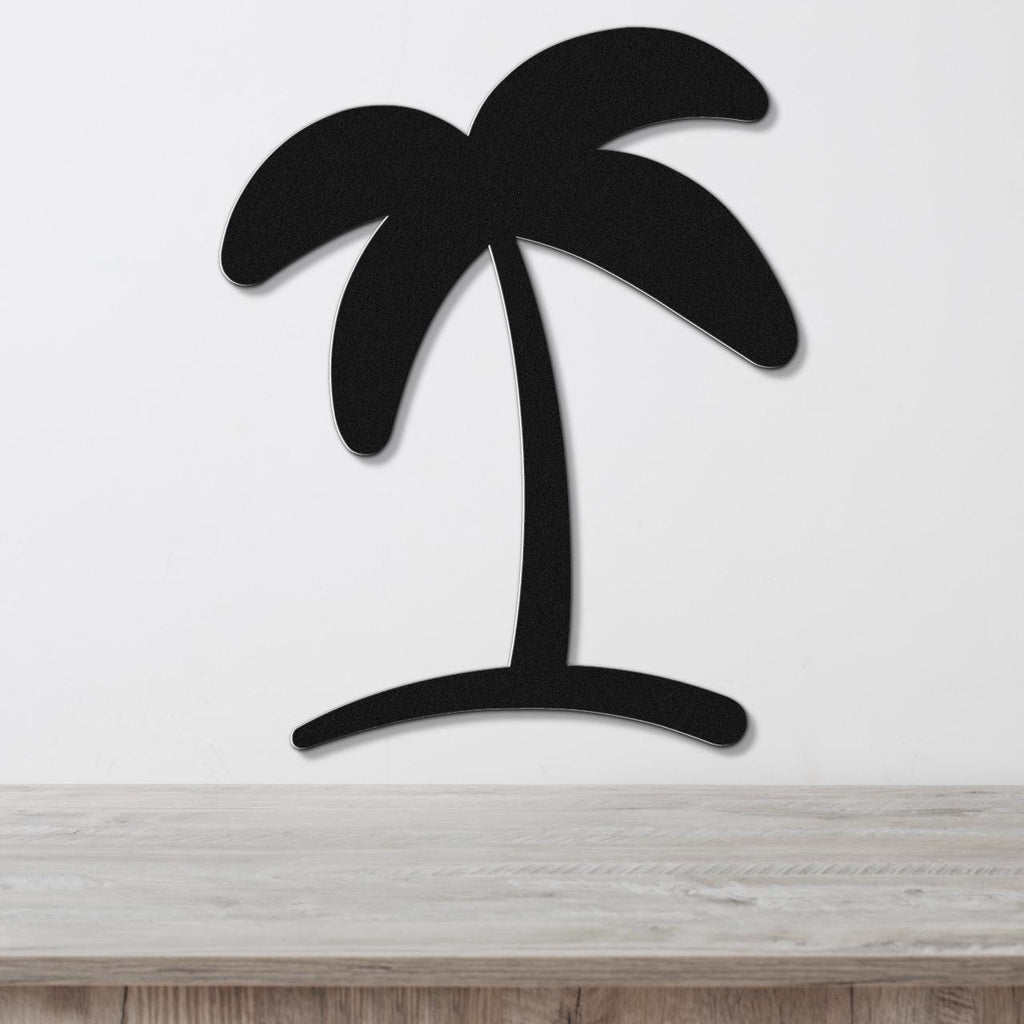 Black metal palm tree wall art with a silhouette design, mounted on a white wall above a light wood surface.