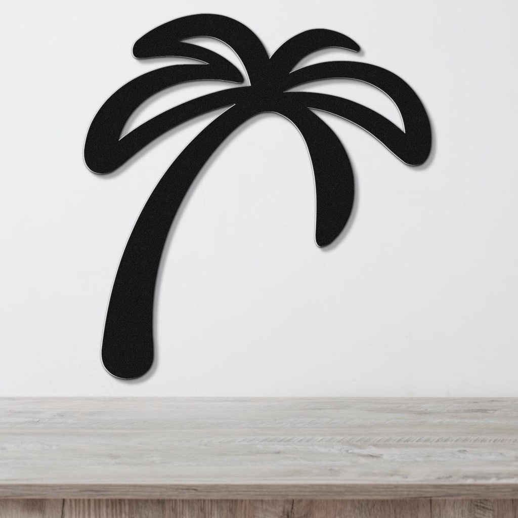 Black metal palm tree wall art with a curved trunk and frond cutouts, mounted on a white wall above a light wood surface.
