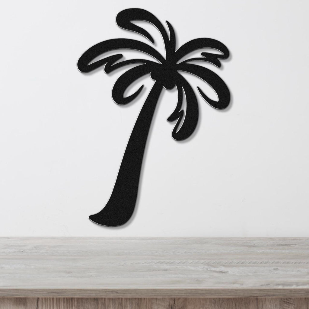 Black metal palm tree wall art with leaf cutouts, mounted on a white wall above a light wood surface.