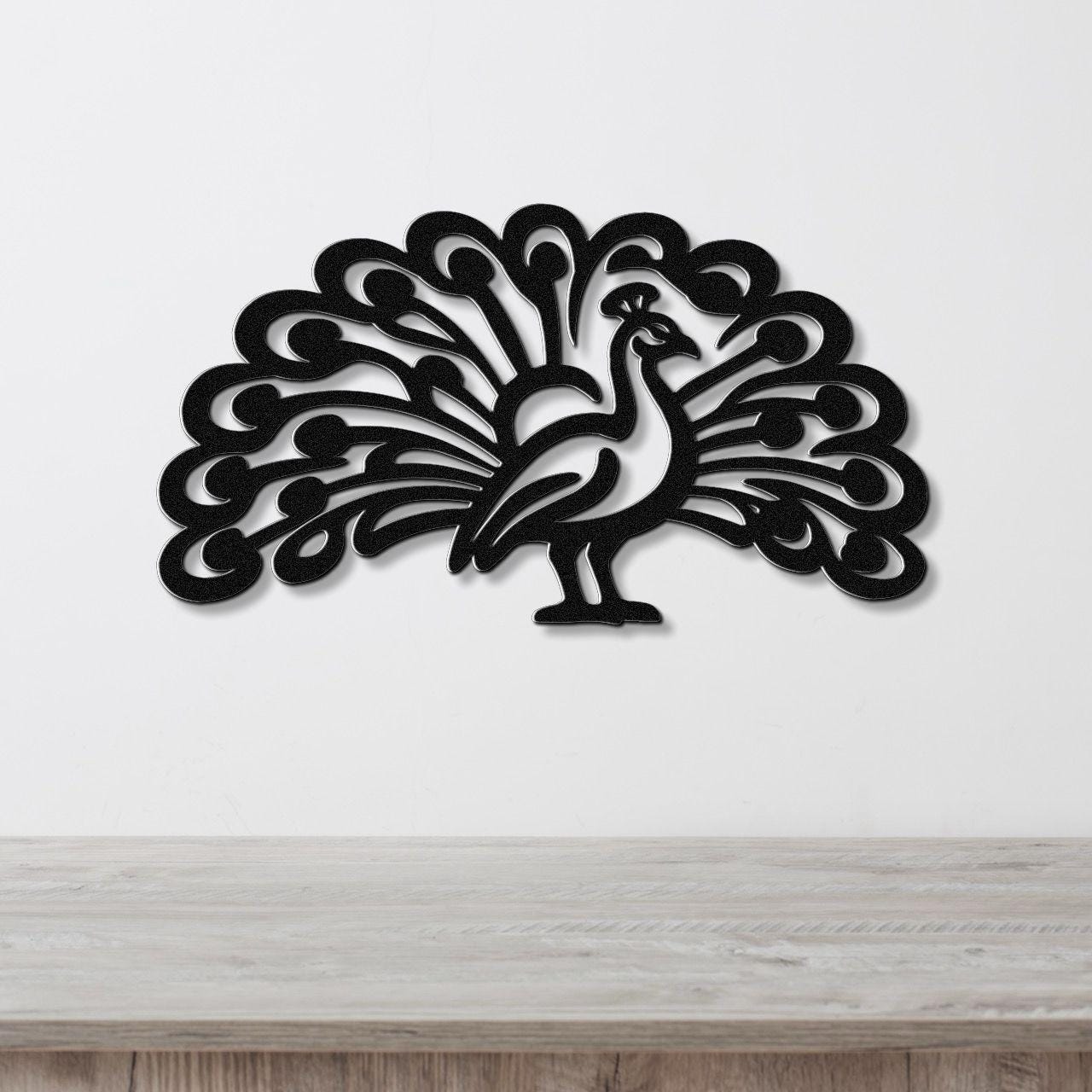Black metal peacock wall art with intricate feather cutouts, mounted on a white wall above a light wood counter.