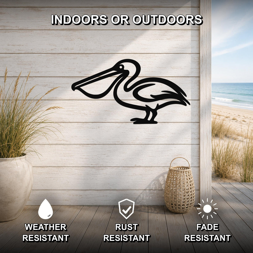 Black metal pelican wall art silhouette mounted on a light wood plank wall, displayed on a patio with a beach view, weather resistant, rust resistant, and fade resistant.