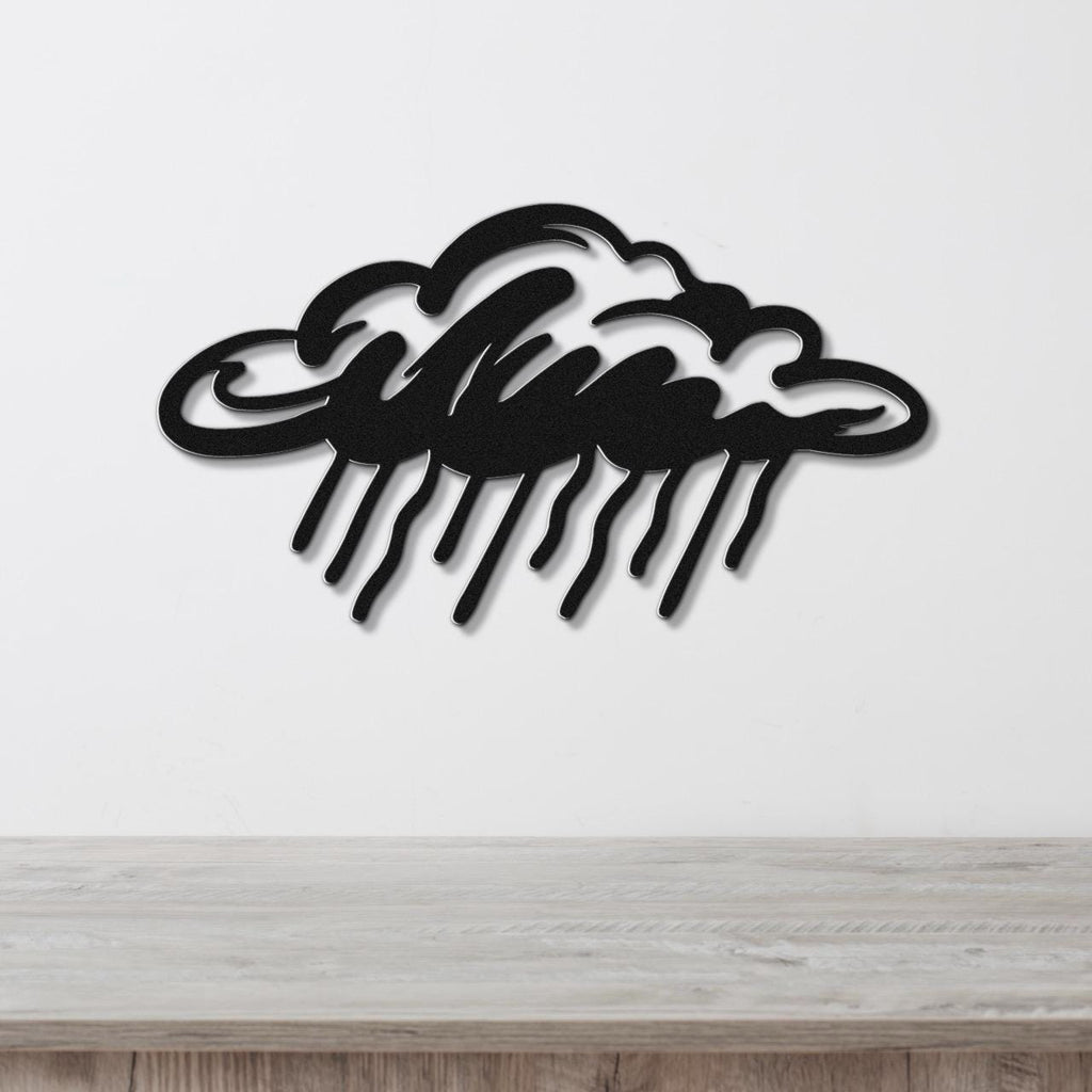 Black metal wall art in a cloud shape with raindrop cutouts, mounted on a white wall above a wooden surface.
