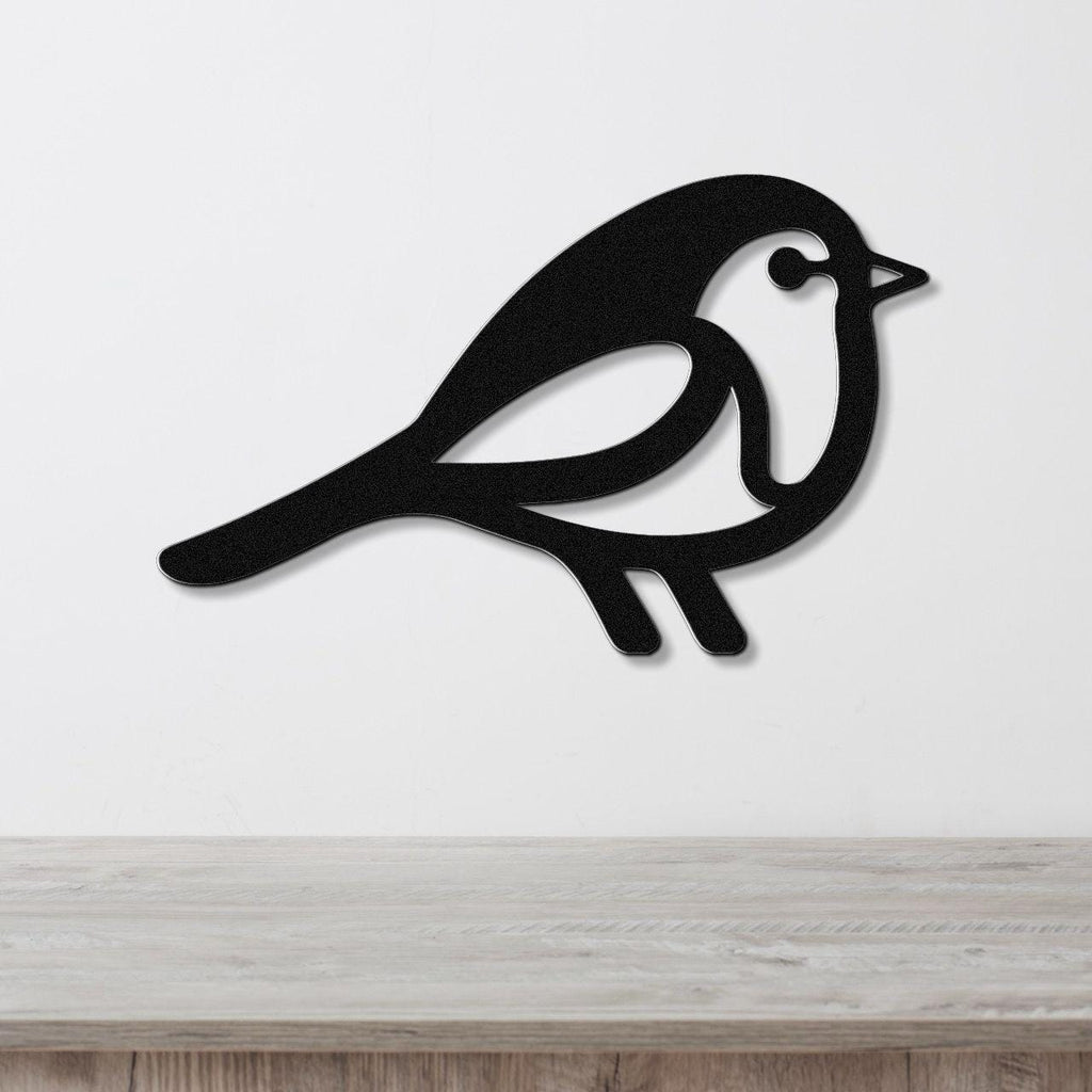Black metal robin wall art with a cutout silhouette design, mounted on a white wall above a light wood surface.