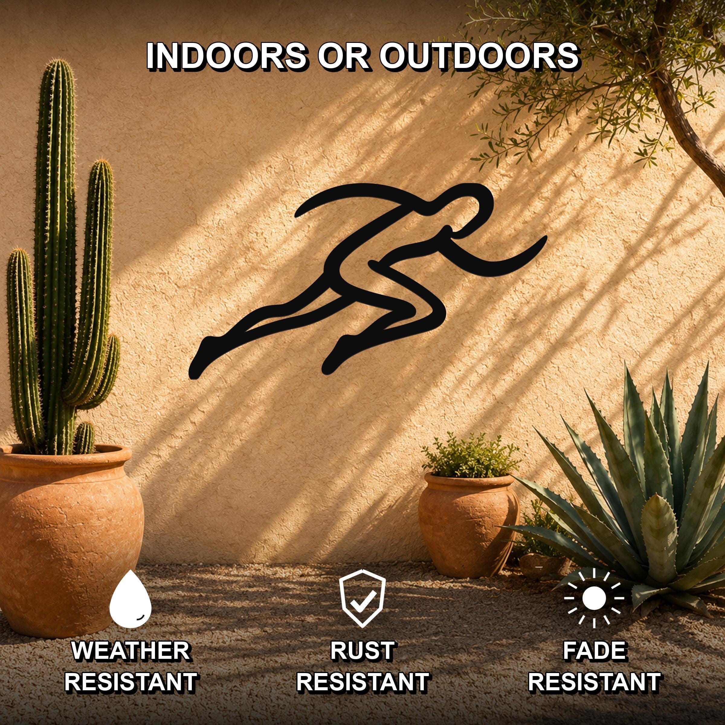 Black metal runner wall art with motion-line cutouts, mounted on an outdoor stucco wall beside potted cacti and succulents.