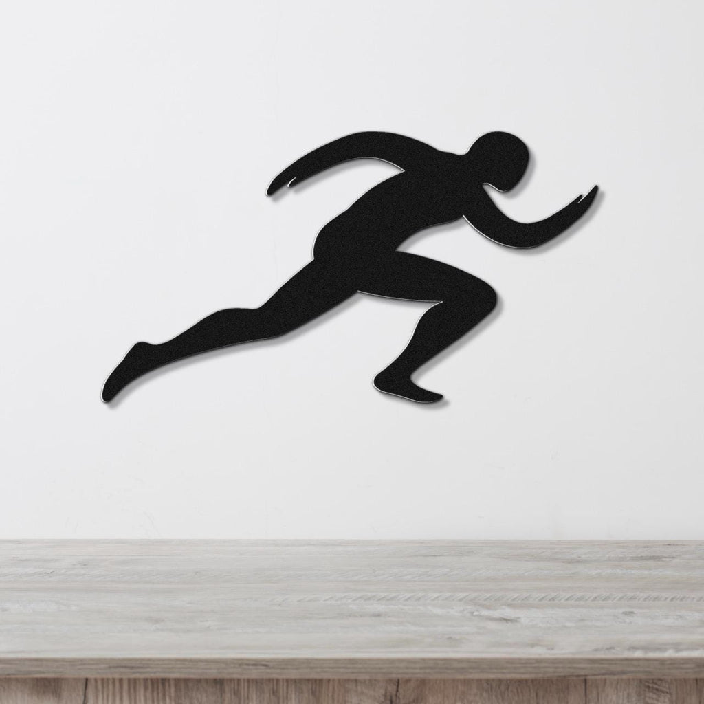 Black metal runner wall art with motion-line cutouts, mounted on a white wall above a light wood counter.
