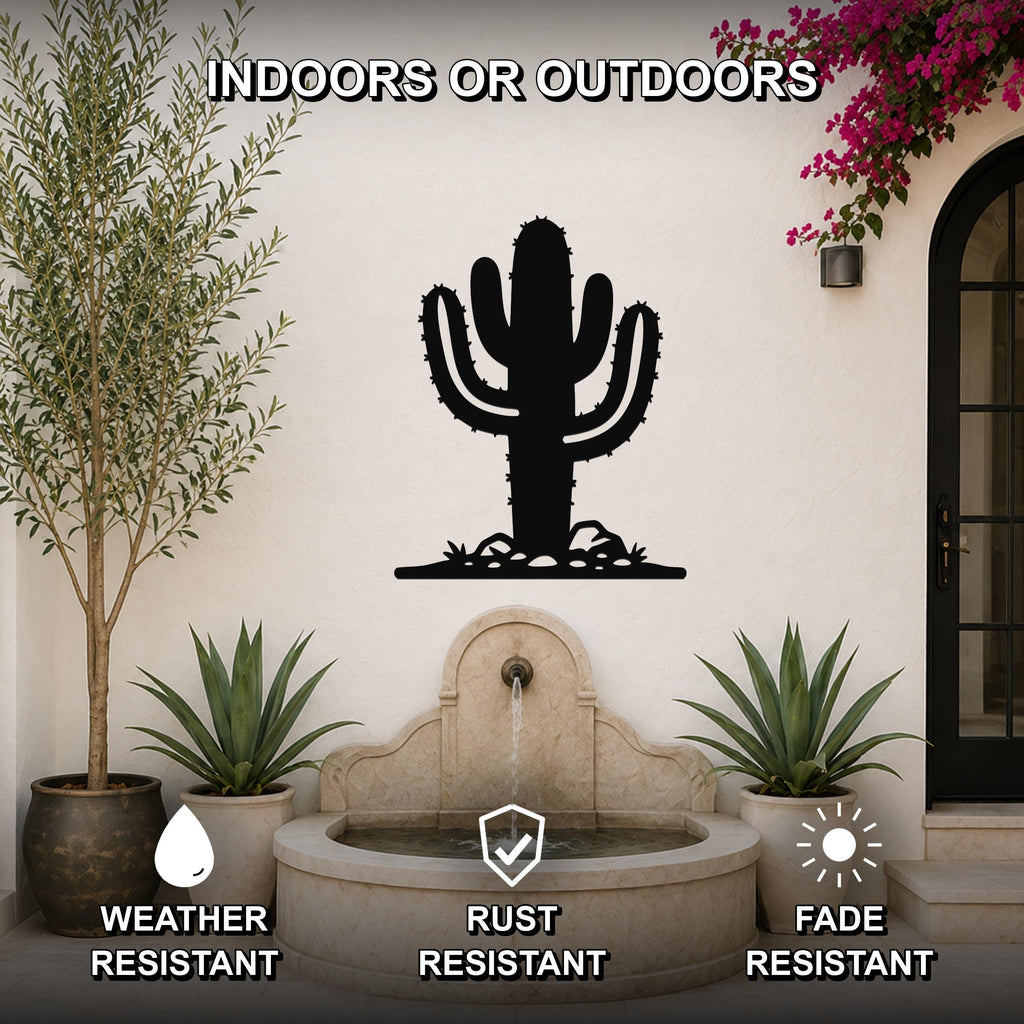 Black metal saguaro cactus wall art with spines and base cutouts, mounted on an outdoor wall above a stone fountain in a patio setting.