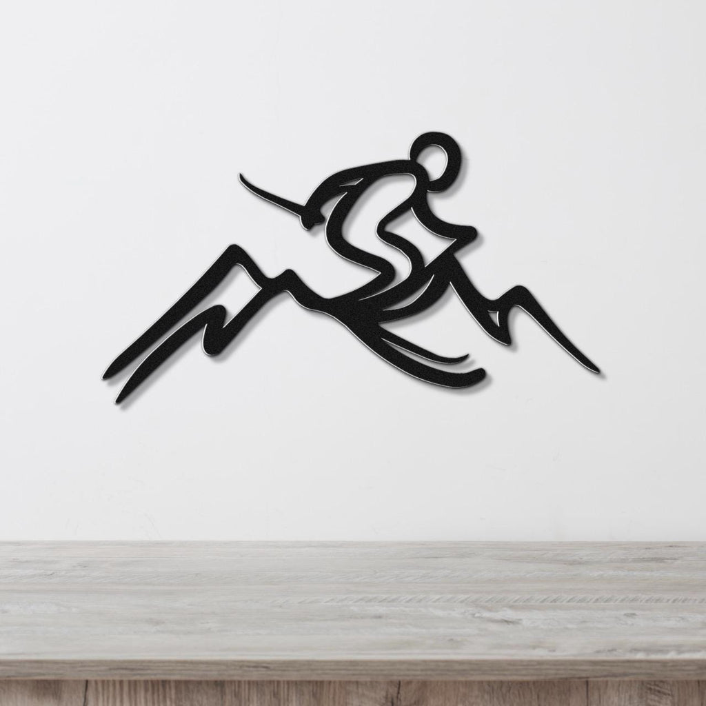 Black metal wall sculpture of a skier in motion above mountain peaks, mounted on a white wall above a light wood counter.