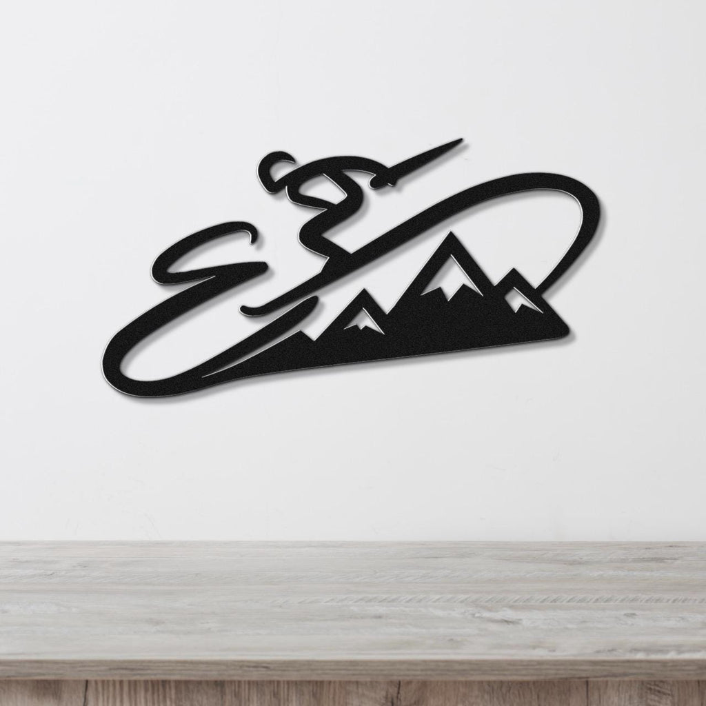 Black metal wall art featuring a skier in motion above a mountain silhouette, mounted on a white wall above a wooden surface.
