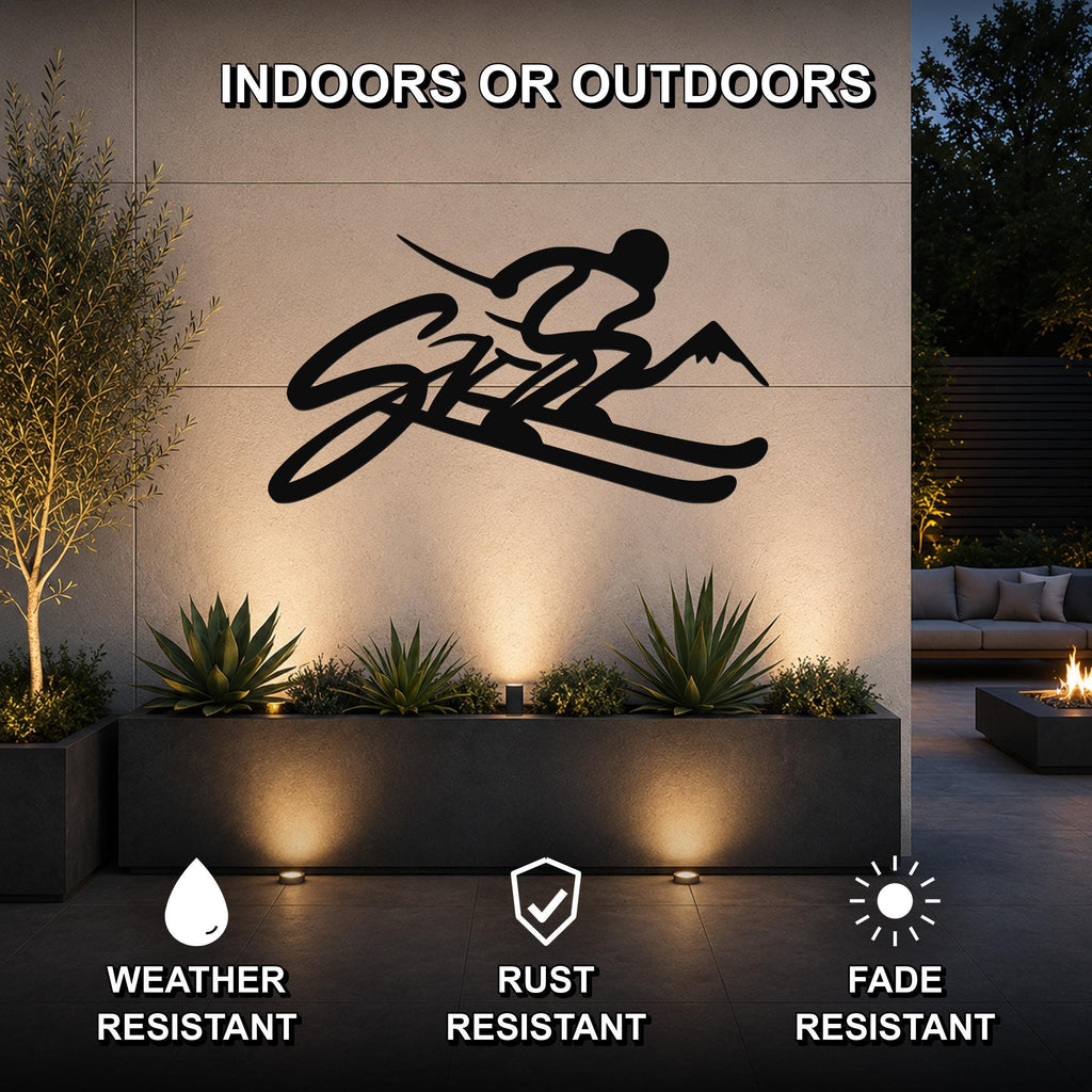 Black metal skiing wall art with a silhouette of a skier and mountain peaks, mounted on an outdoor wall above a planter in a modern patio setting.