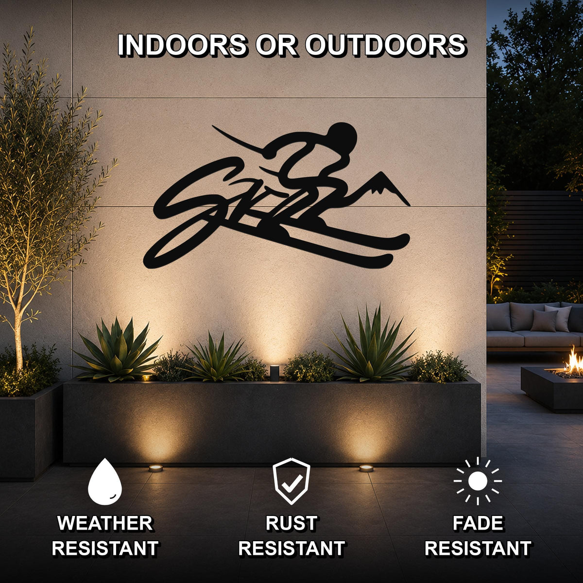 Black metal skiing wall art with a silhouette of a skier and mountain peaks, mounted on an outdoor wall above a planter in a modern patio setting.