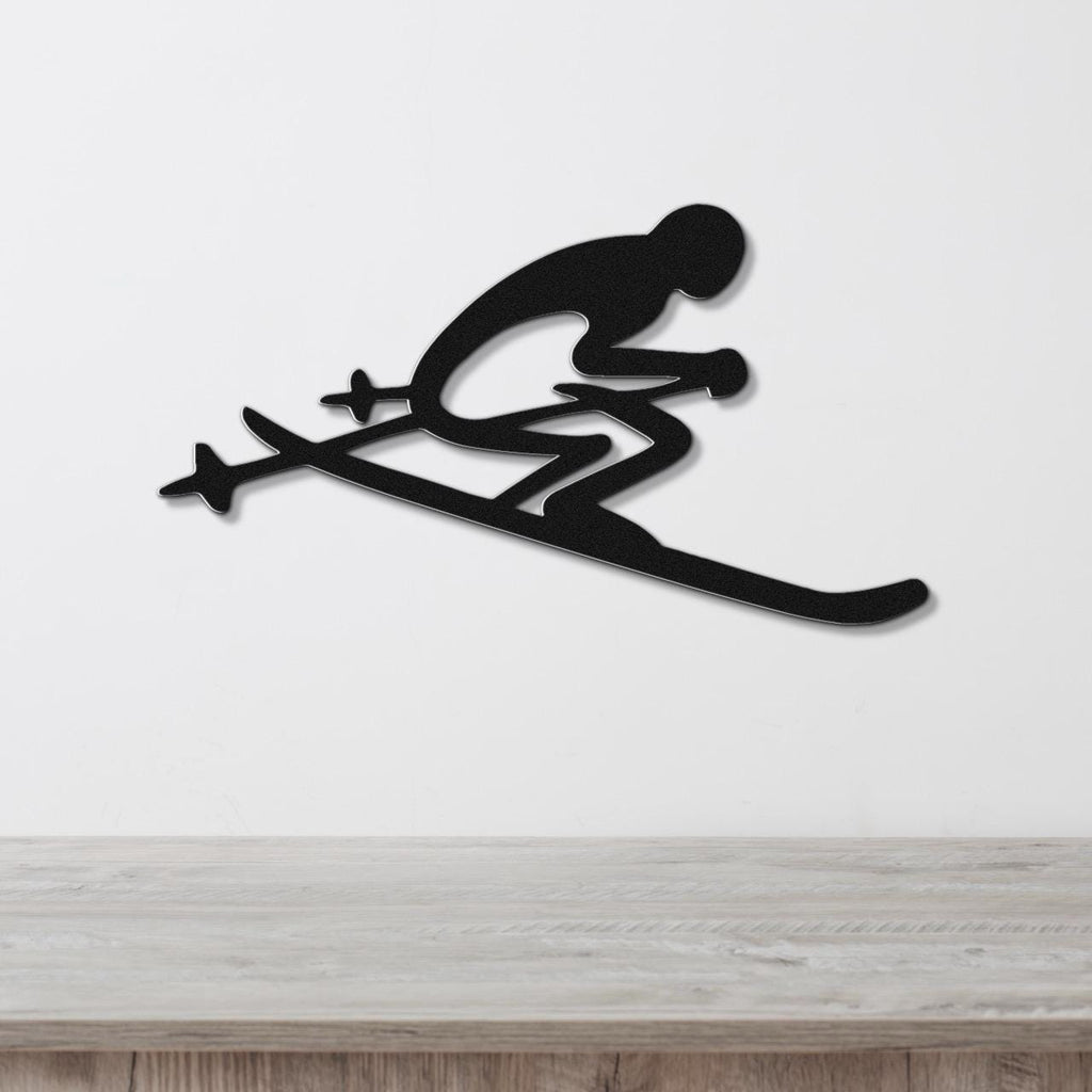 Black metal wall art of a skier silhouette with ski poles and skis, mounted on a white wall above a wooden surface.