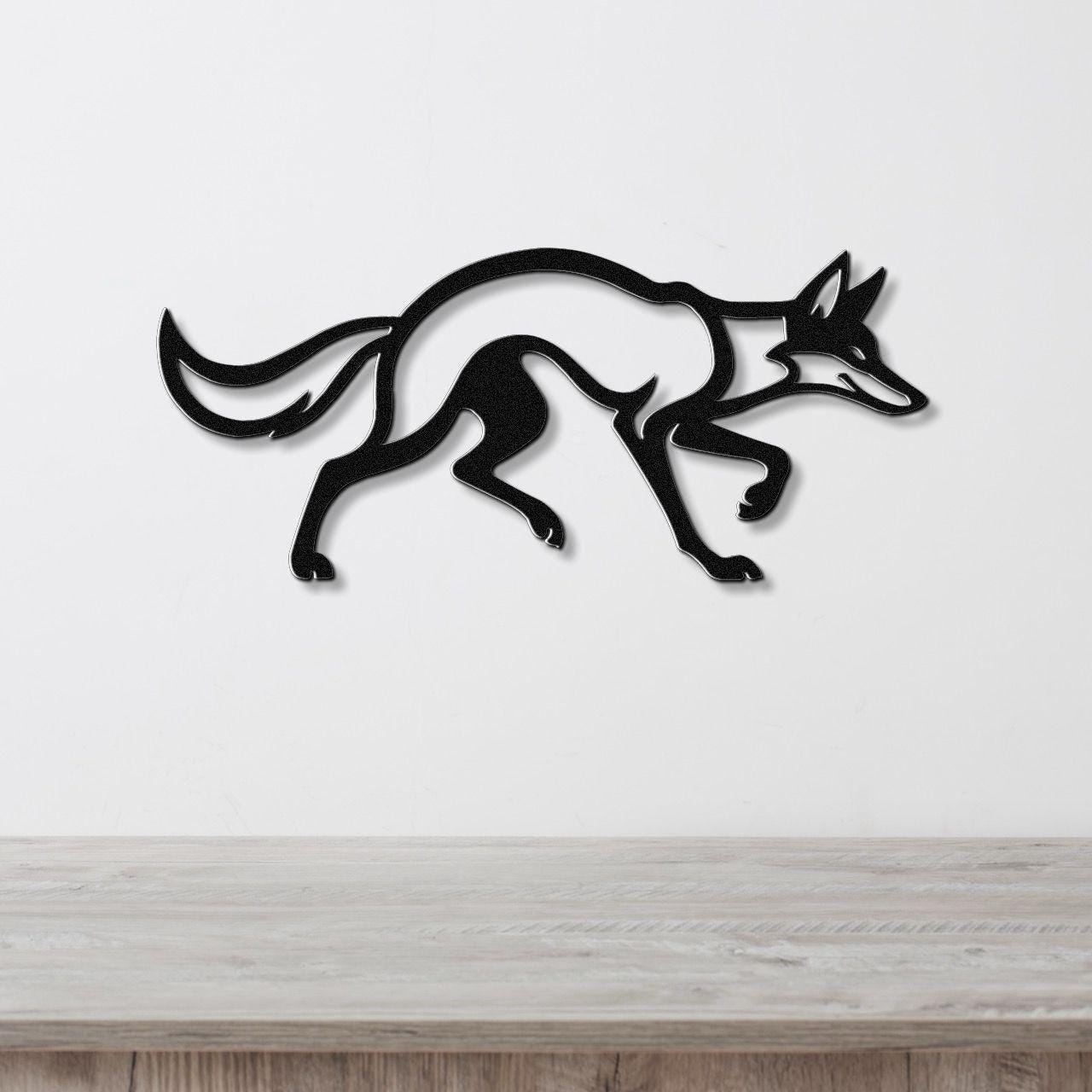 Black metal coyote wall art with a sleek silhouette and motion-line cutouts, mounted on a white wall above a light wood counter.