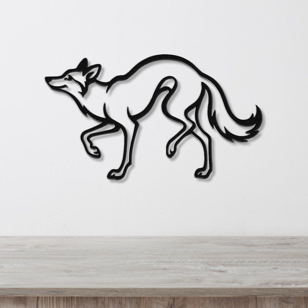 Black metal coyote wall art with a sleek silhouette design, mounted on a white wall above a light wood surface.