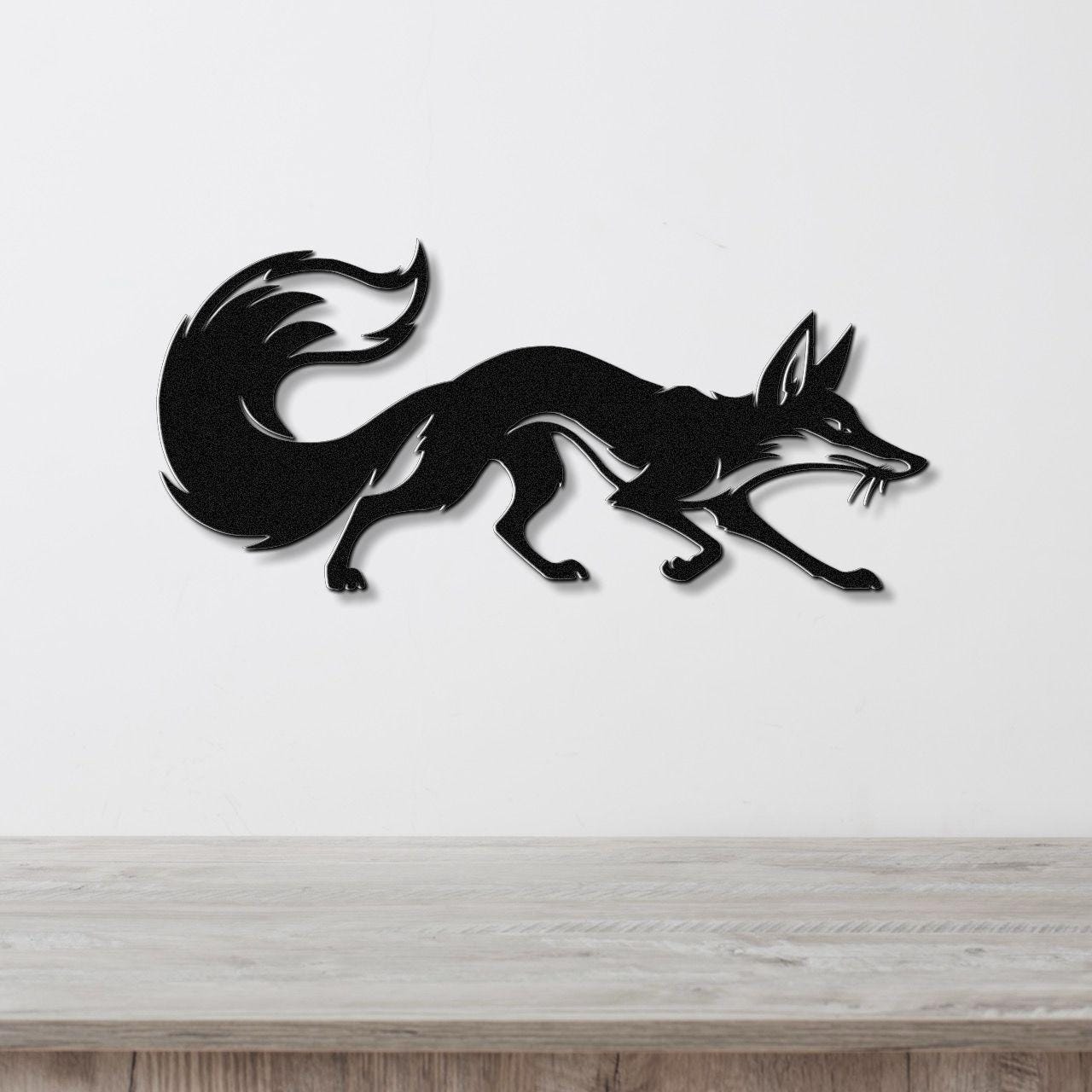 Black metal fox wall art in a running silhouette with a curled tail, mounted on a white wall above a light wood countertop.