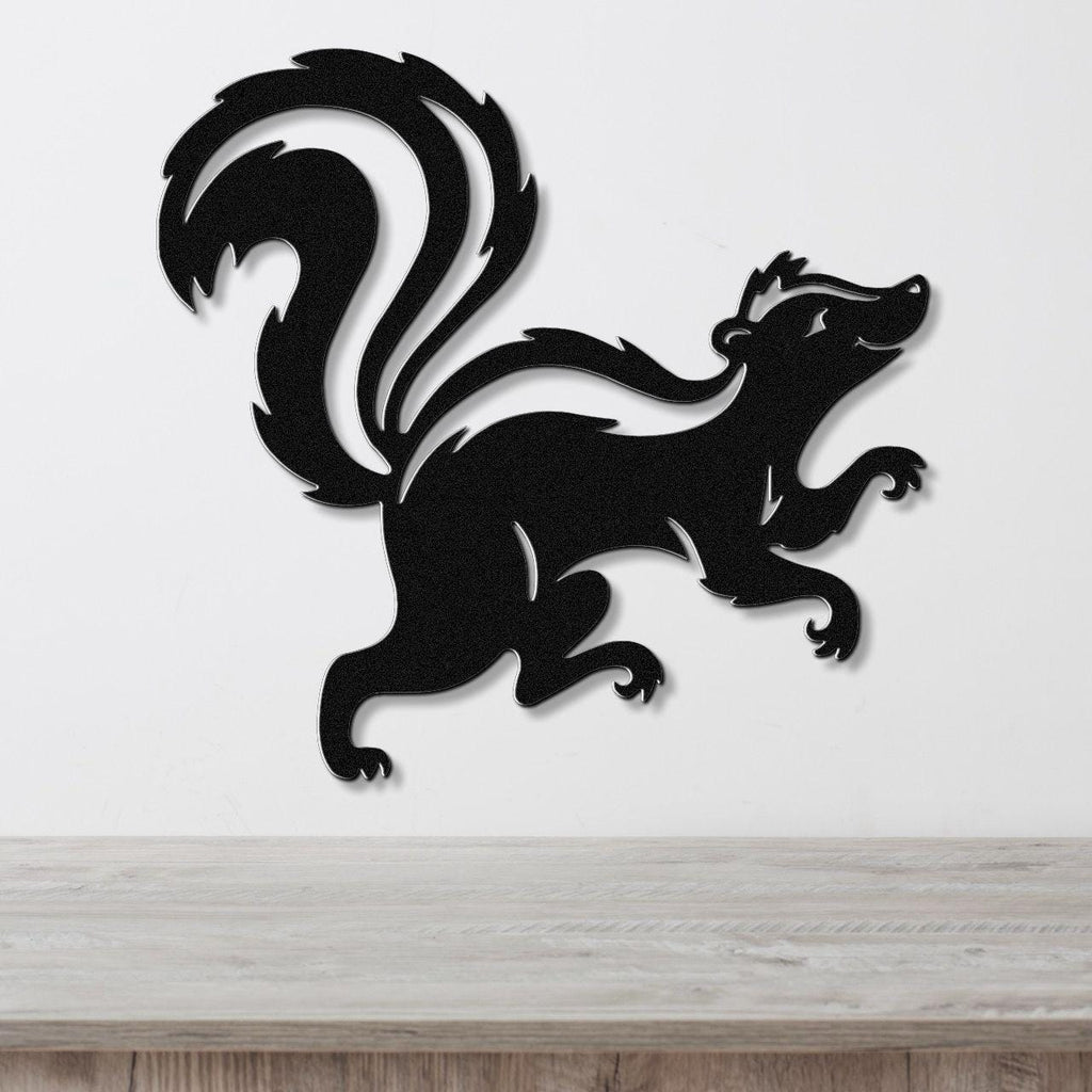 Black metal skunk wall art with a curved tail and white stripe cutout, mounted on a white wall above a light wood countertop.