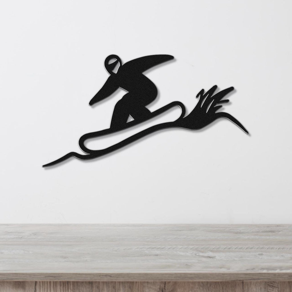 Black metal wall sculpture of a snowboarder in motion, with dynamic cutout lines, mounted on a white wall above a wooden counter.