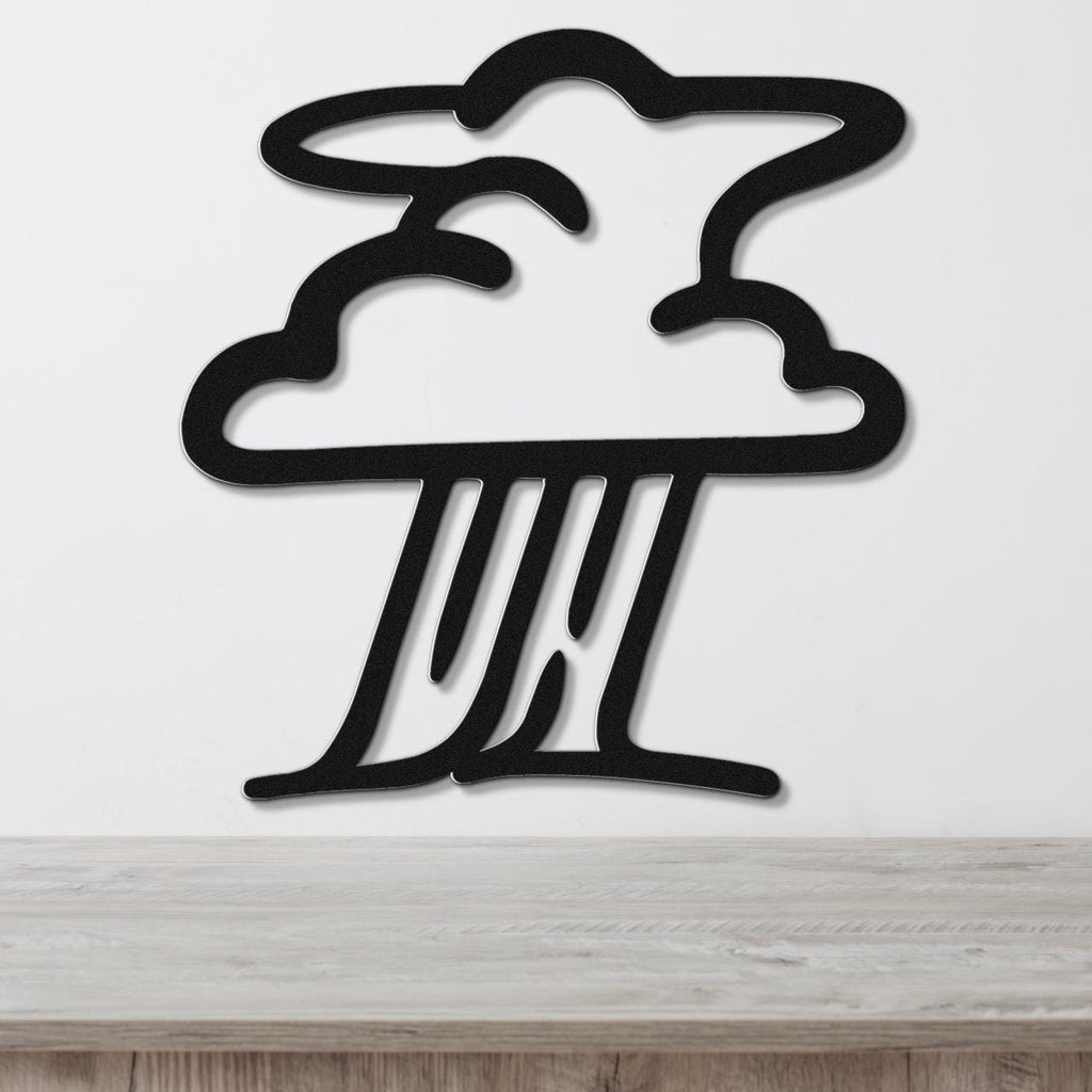 Black metal wall art in a storm cloud silhouette with raindrop cutouts, mounted on a white wall above a light wood surface.