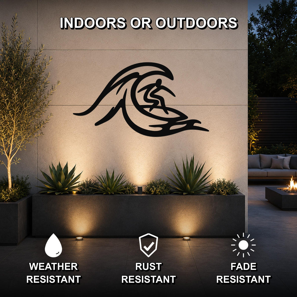 Black metal surfer wall art with wave cutout design, mounted on an outdoor patio wall above a planter with succulents.