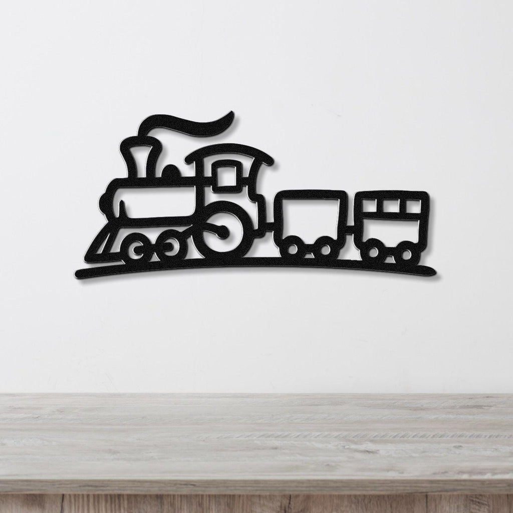 Black metal train wall art with a silhouette design of a locomotive and two cars, mounted on a white wall above a wooden surface.