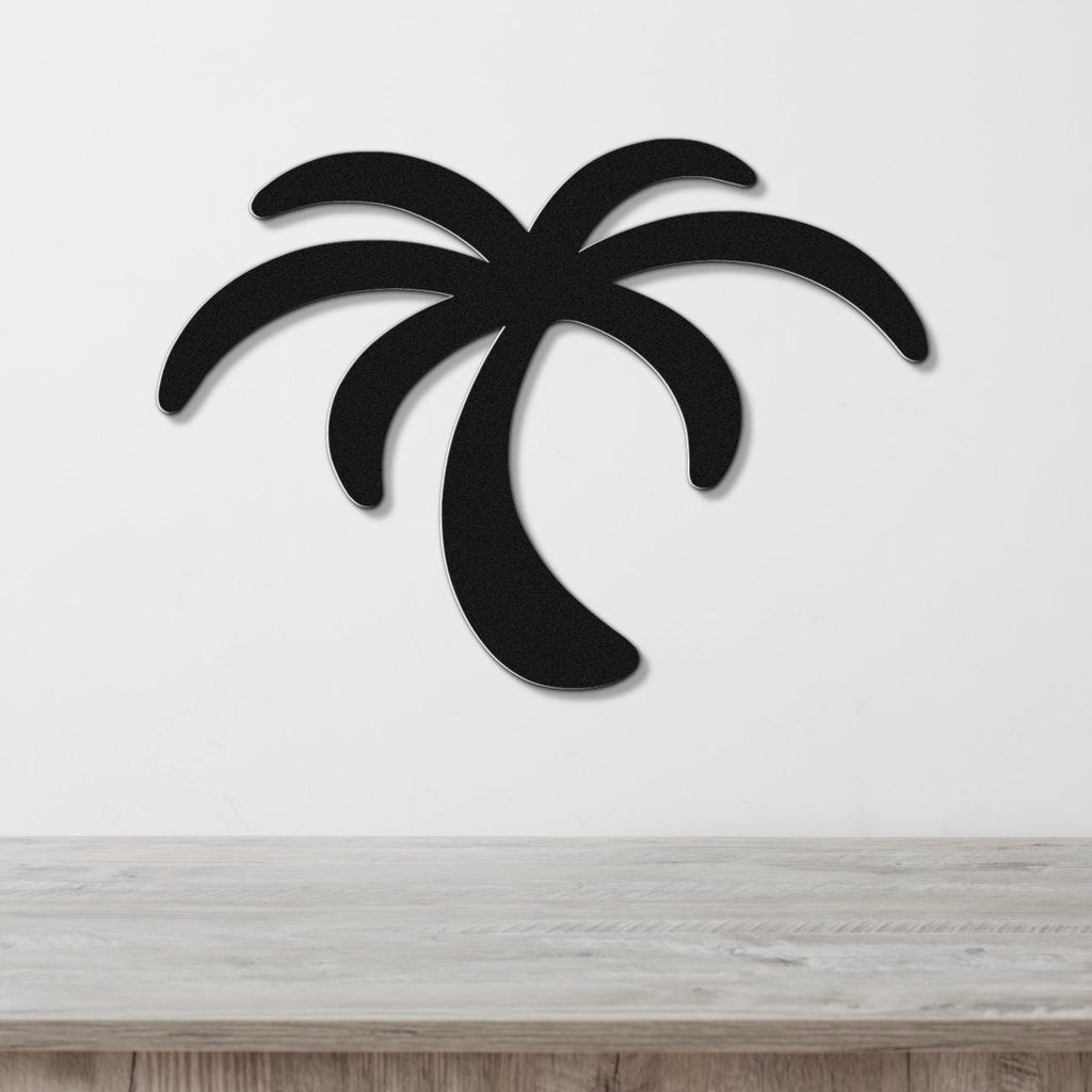 Black metal palm tree wall art with a silhouette design, mounted on a white wall above a light wood surface.