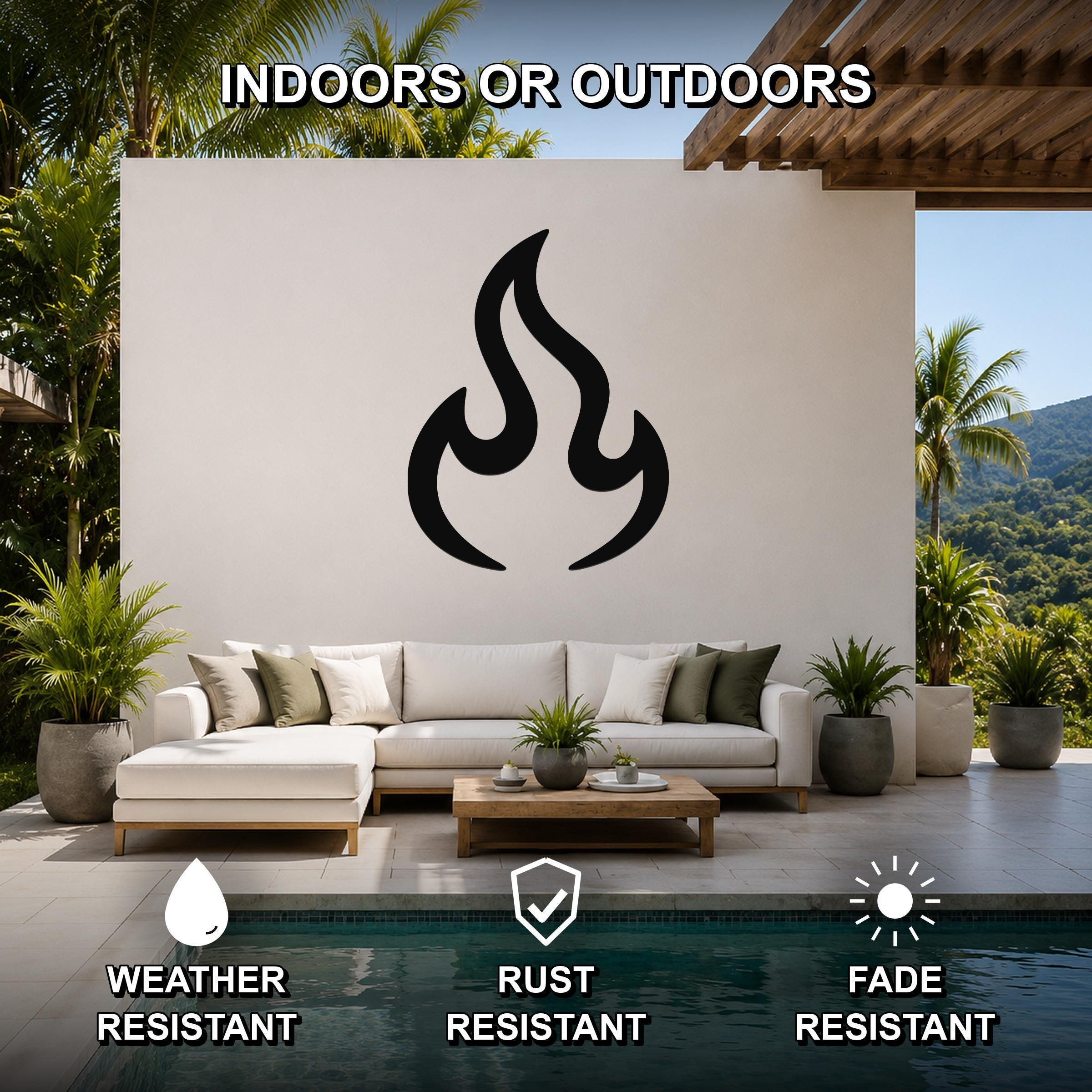 Black metal flame silhouette wall art mounted on a white outdoor wall above a white sectional sofa in a patio living area.