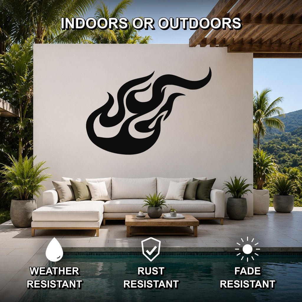 Black metal flame wall sculpture with flowing silhouette, mounted on a white outdoor wall above a sofa in a patio living area.