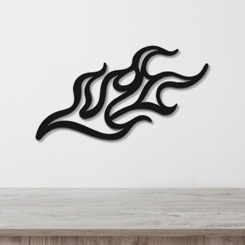 Black metal wall art with a fluid flame design, featuring interwoven curves and cutouts, mounted on a white wall above a light wood surface.