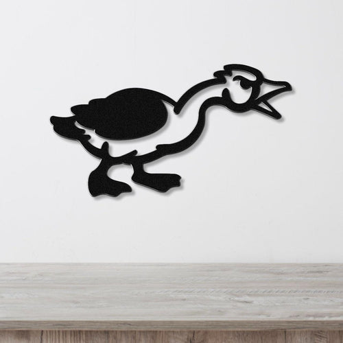 Black metal wall art silhouette of a goose in motion, mounted on a white wall above a light wood surface.