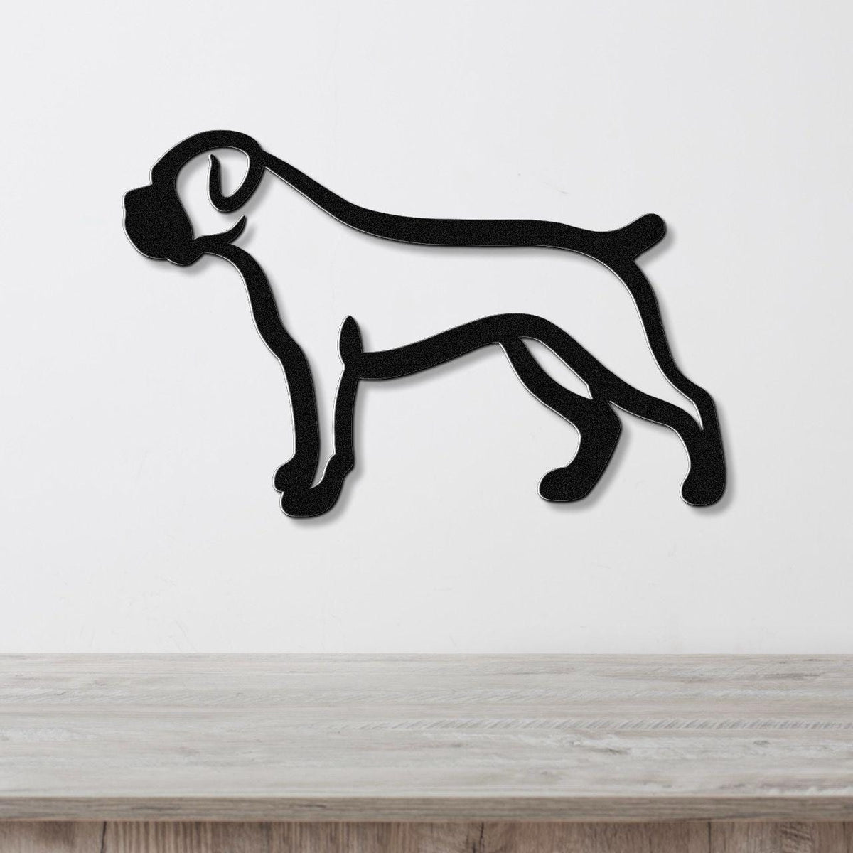 Black metal Boxer dog silhouette wall art with clean lines, mounted on a white wall above a light wood surface.