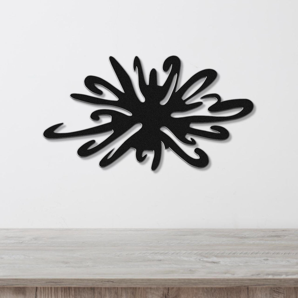 Black metal sea urchin wall art with organic spines and cutout details, mounted on a white wall above a wooden surface.