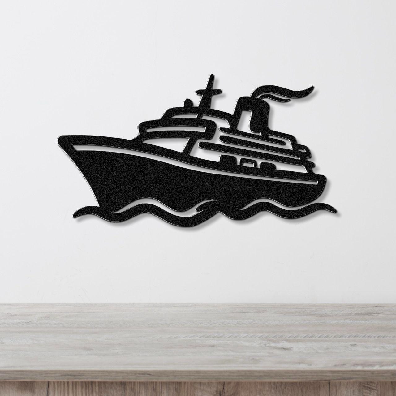 Black metal wall art cutout of a cruise ship with wavy water lines, mounted on a white wall above a light wood counter.