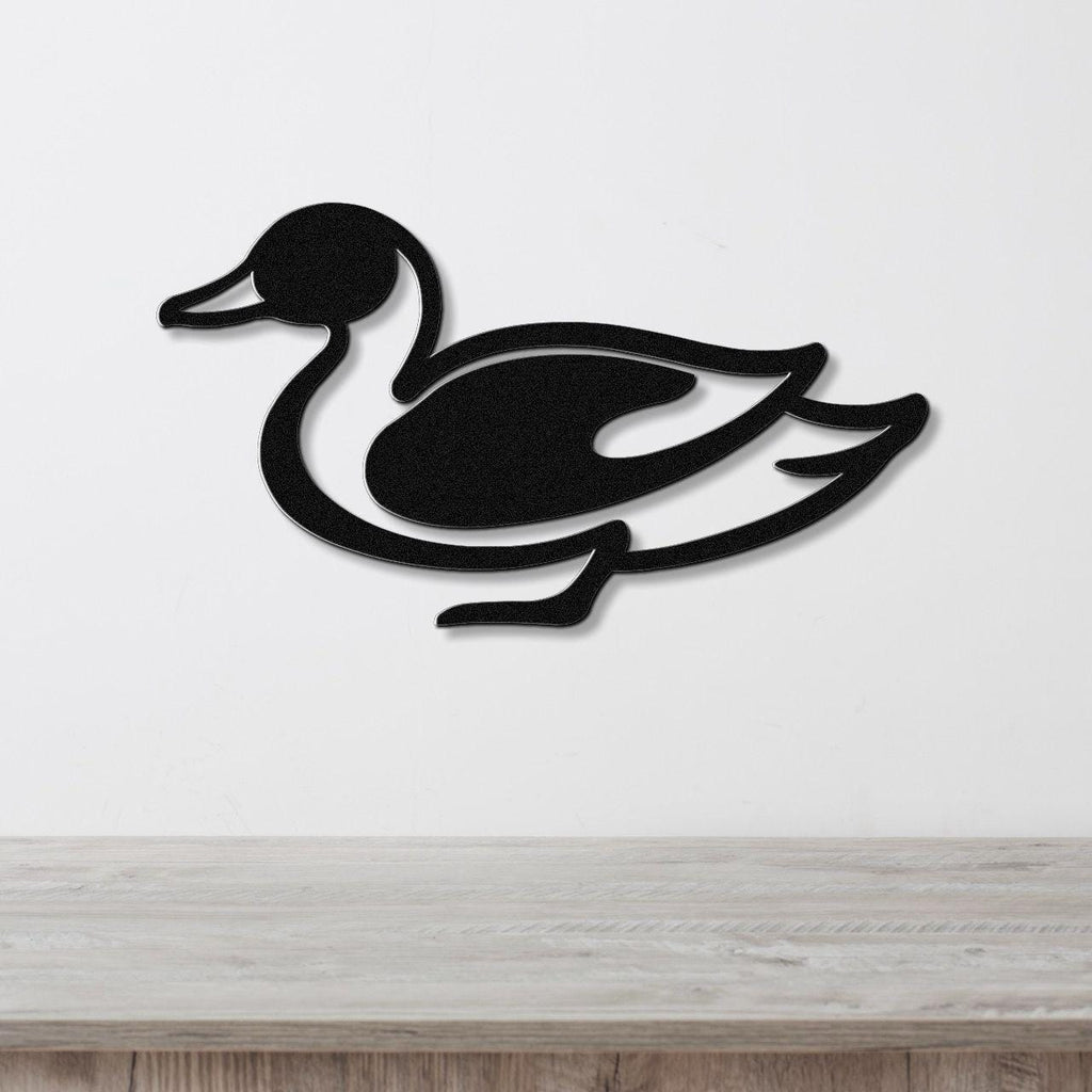 Black metal duck wall sculpture with a cutout silhouette design, mounted on a white wall above a light wood countertop.