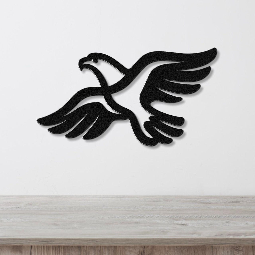 Black metal eagle wall art with outstretched wings and internal cutout details, mounted on a white wall above a light wood countertop.