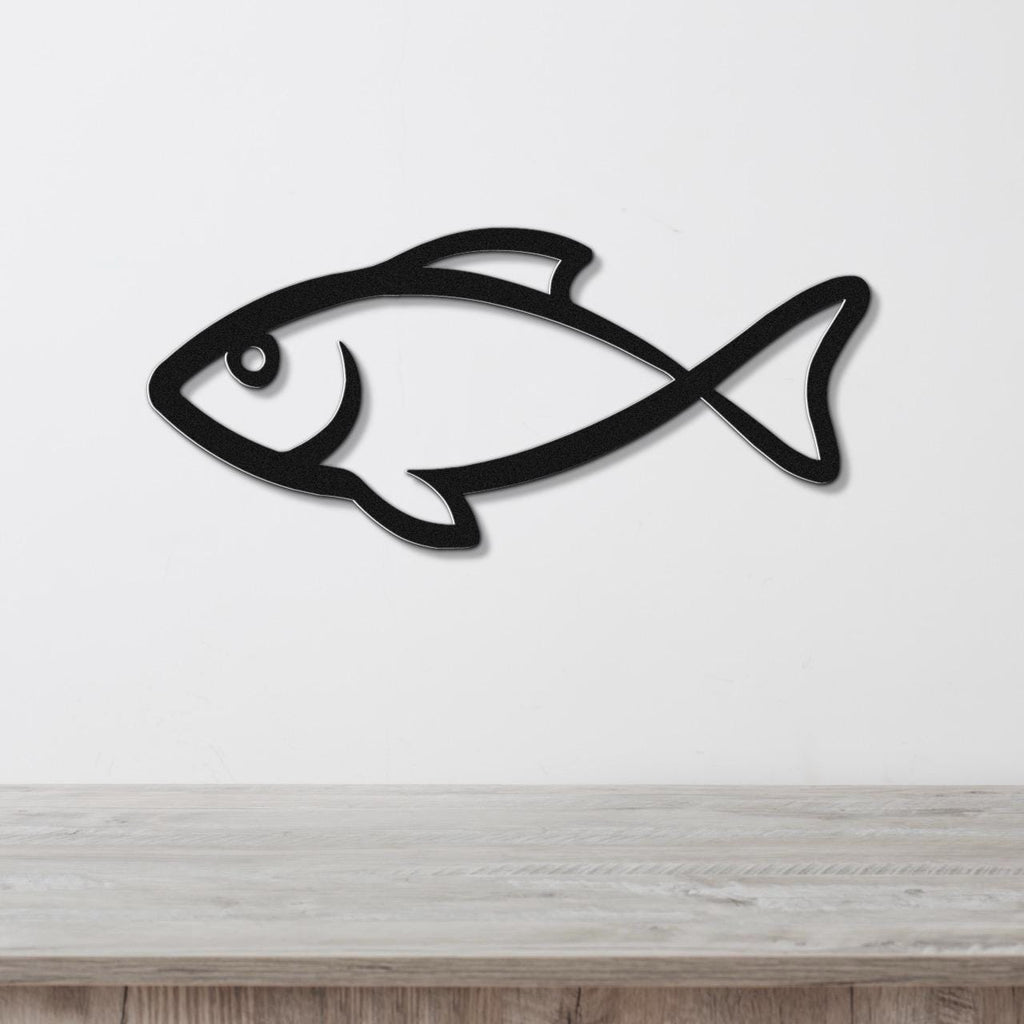 Black metal fish wall art with a silhouette cutout design, mounted on a white wall above a light wood countertop.