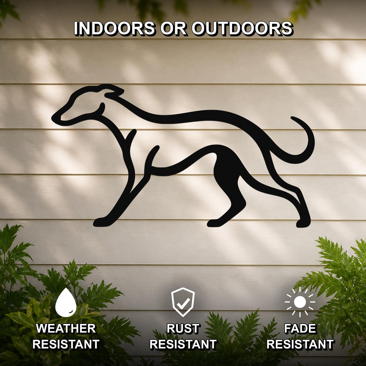 Black metal greyhound silhouette wall art mounted on a light-colored outdoor wall, with green foliage at the base and text indicating it is weather, rust, and fade resistant.