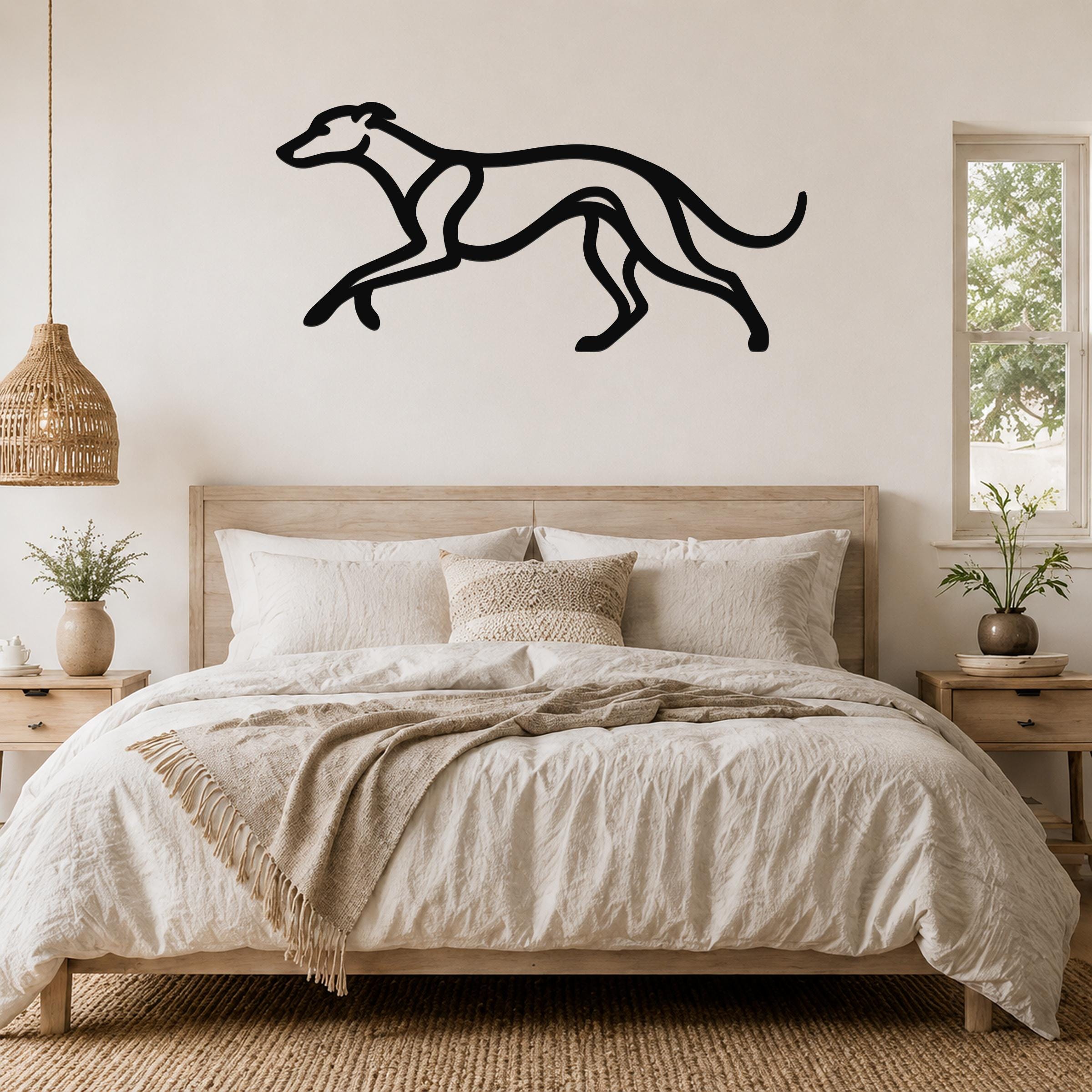 Black metal greyhound wall art in a running silhouette, mounted above a bed in a neutral bedroom.