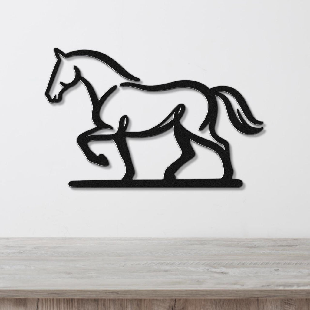 Black metal horse wall art in a silhouette style, mounted on a white wall above a light wood surface.