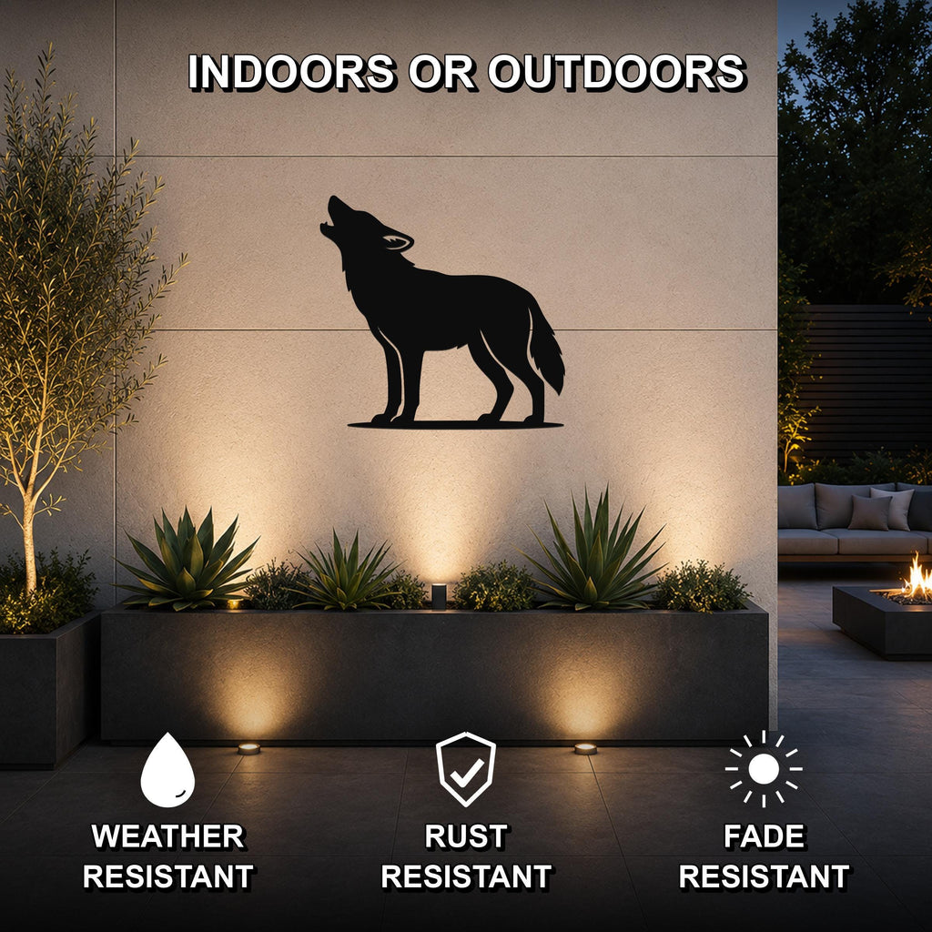 Black metal coyote wall art in a howling silhouette, mounted on an outdoor wall above a planter with succulents, shown in a nighttime patio setting.