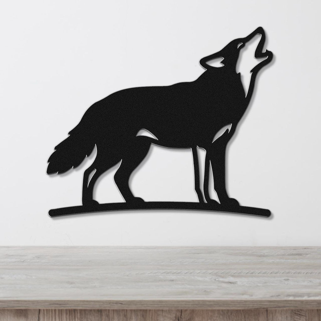 Black metal coyote wall art in a howling silhouette, mounted on a white wall above a light wood counter.