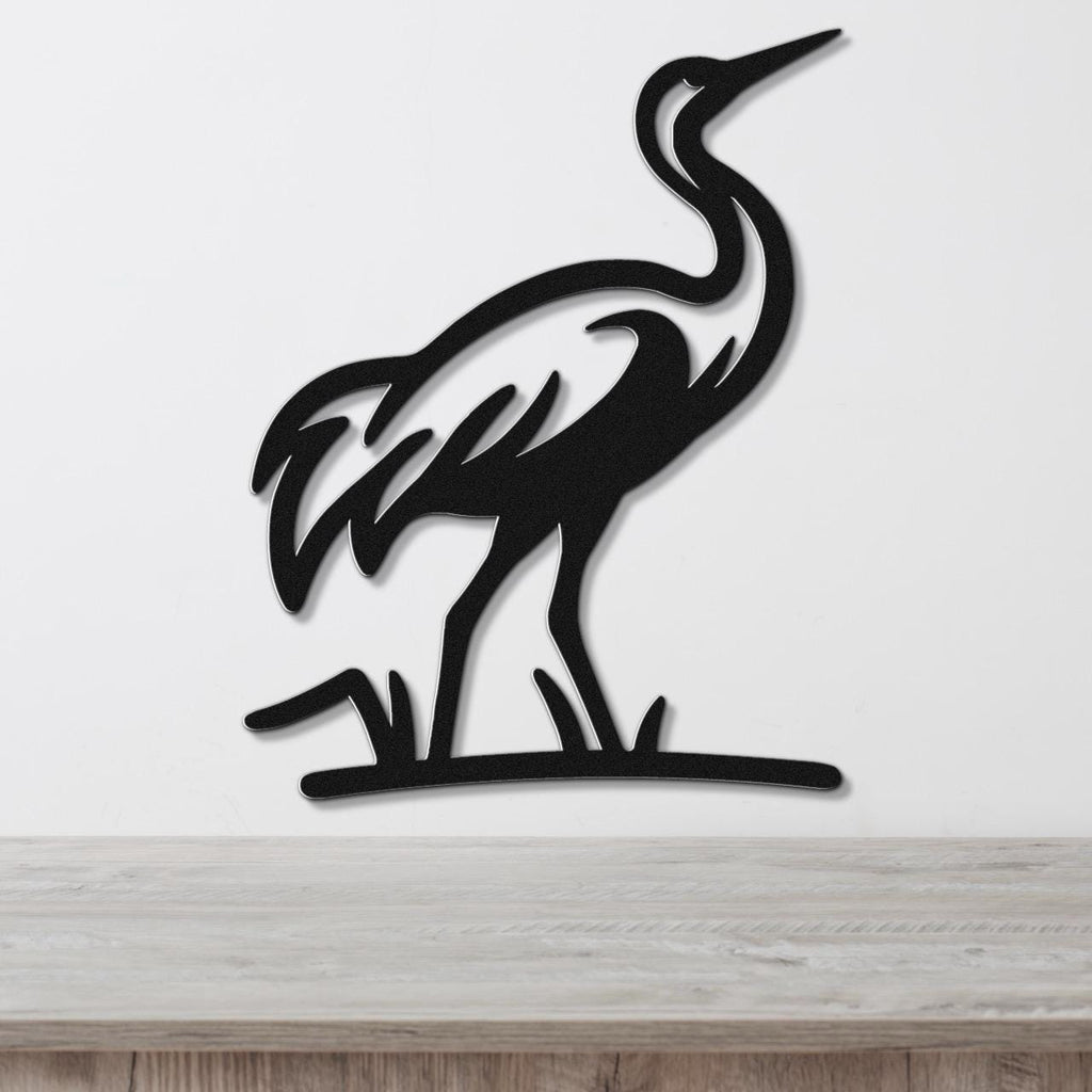 Black metal crane wall art with a silhouette cutout design, mounted on a white wall above a light wood surface.