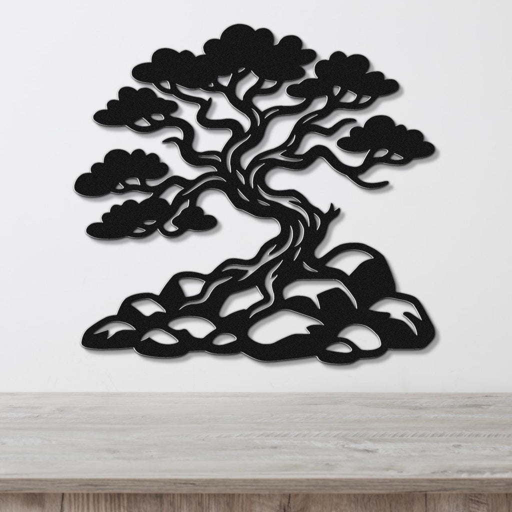 Black metal wall art silhouette of a juniper tree with intricate branches and roots, mounted on a white wall above a wooden counter.
