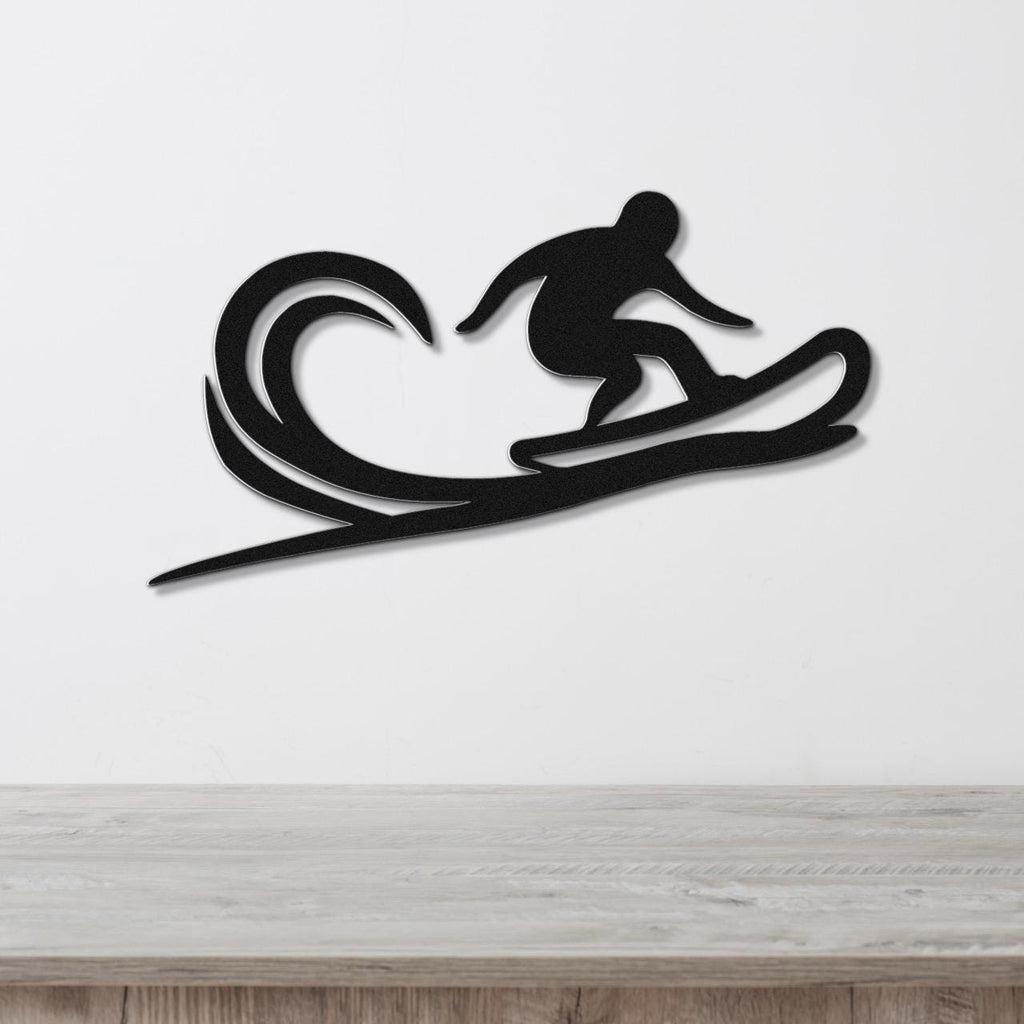 Black metal wall art silhouette of a snowboarder on a wave-shaped board, mounted on a white wall above a wooden counter.