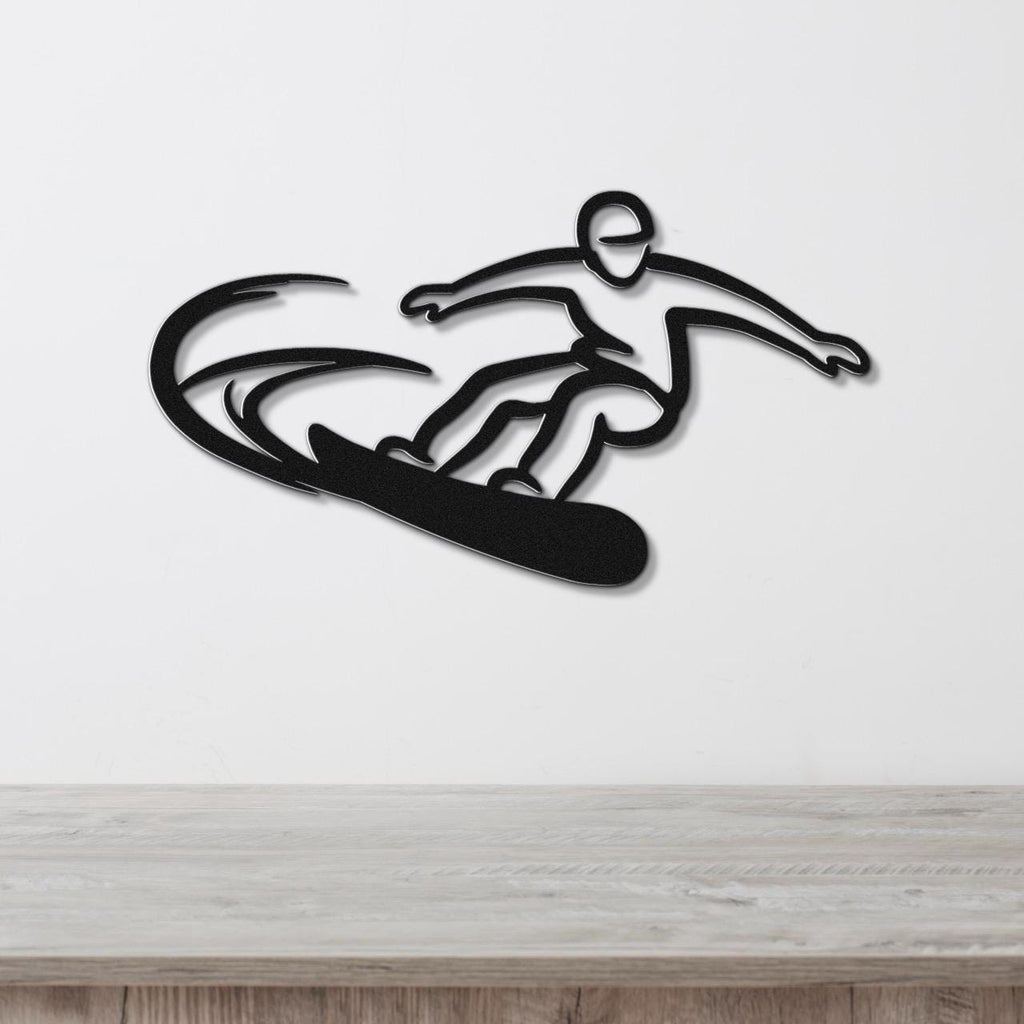 Black metal wall art silhouette of a snowboarder in motion, with dynamic cutout lines for speed, mounted on a white wall above a wooden surface.