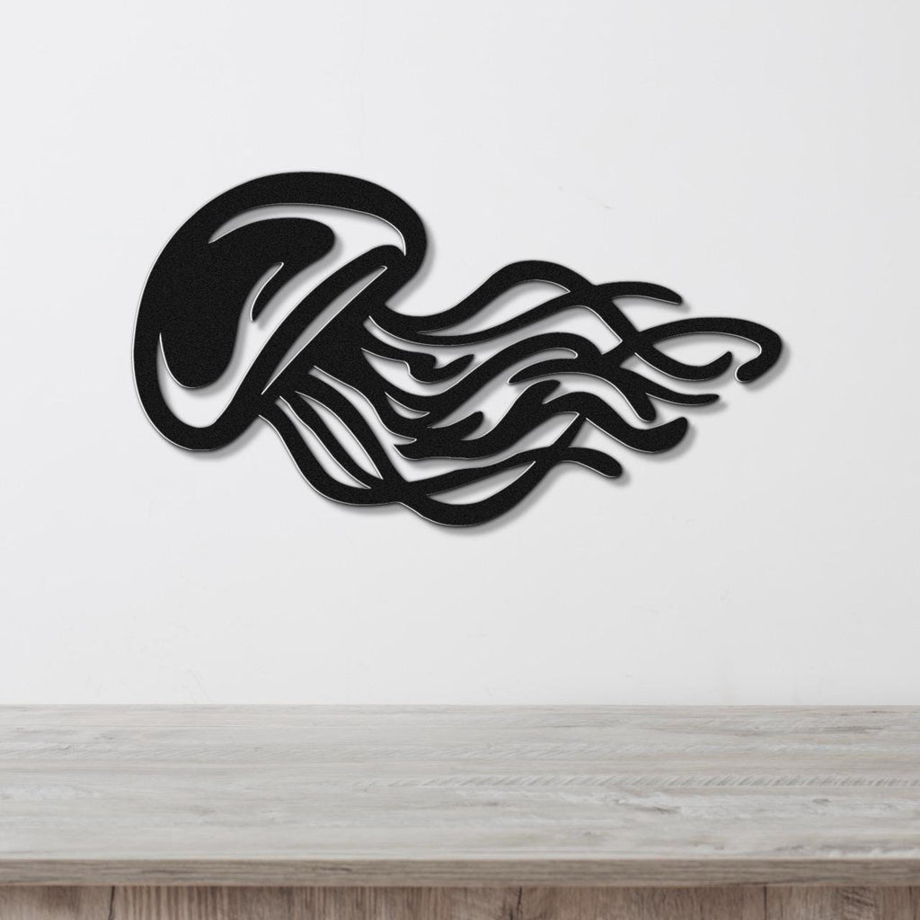 Black metal jellyfish wall art with flowing tentacle cutouts, mounted on a white wall above a light wood counter.
